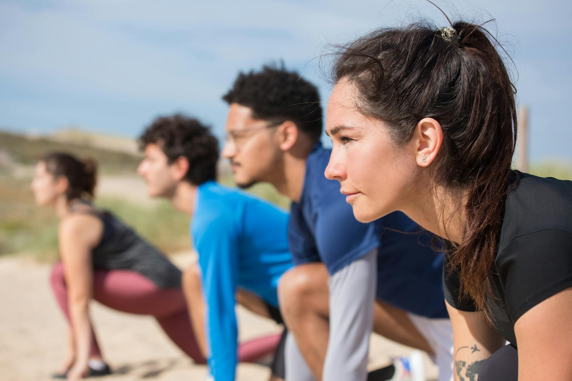 people kneeling together on sand