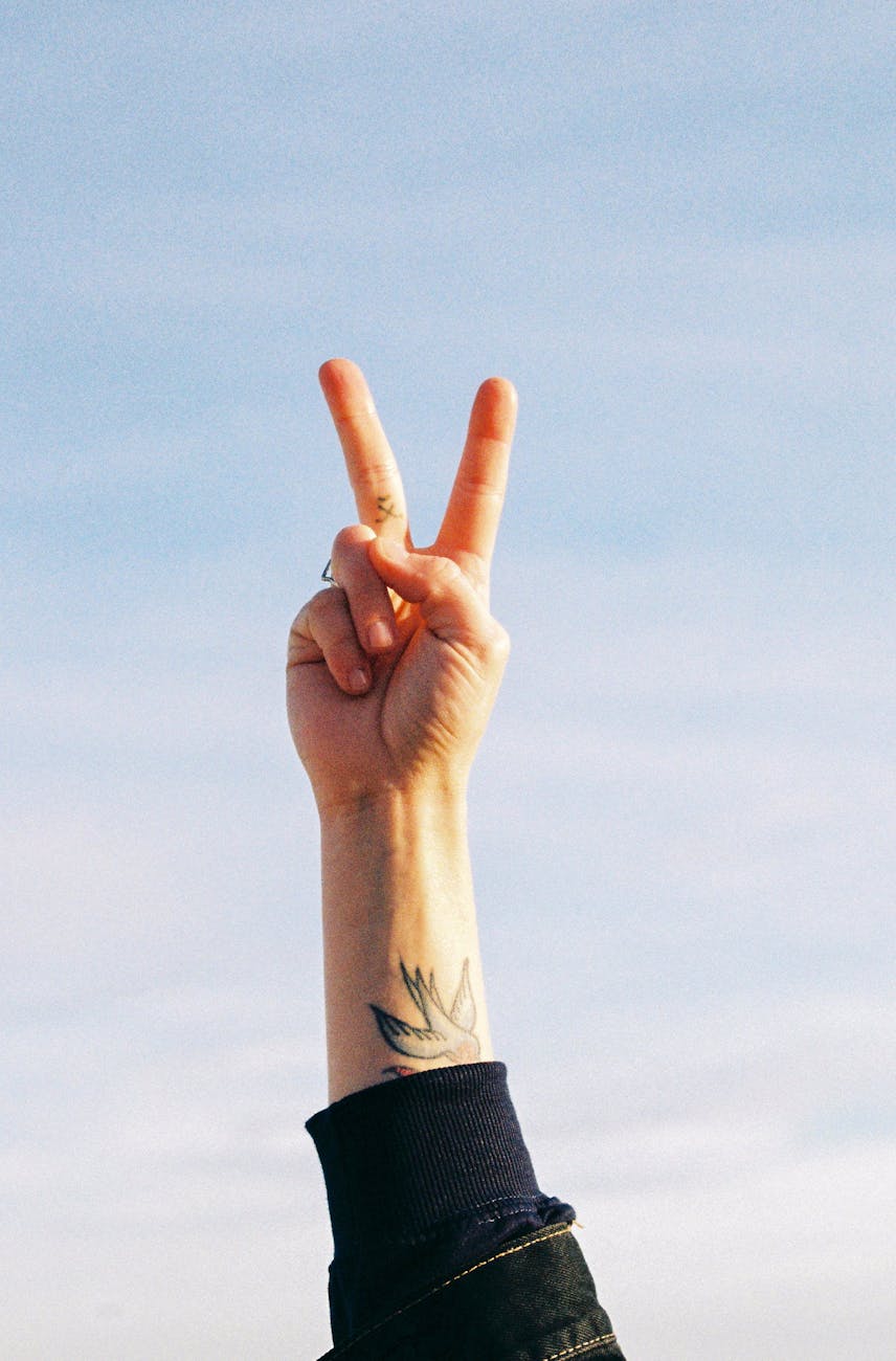 arm of a person making a peace sign