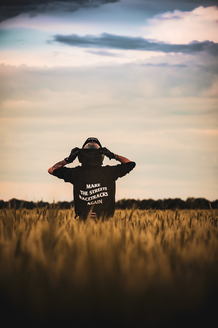 person in field with motivational hoodie back view