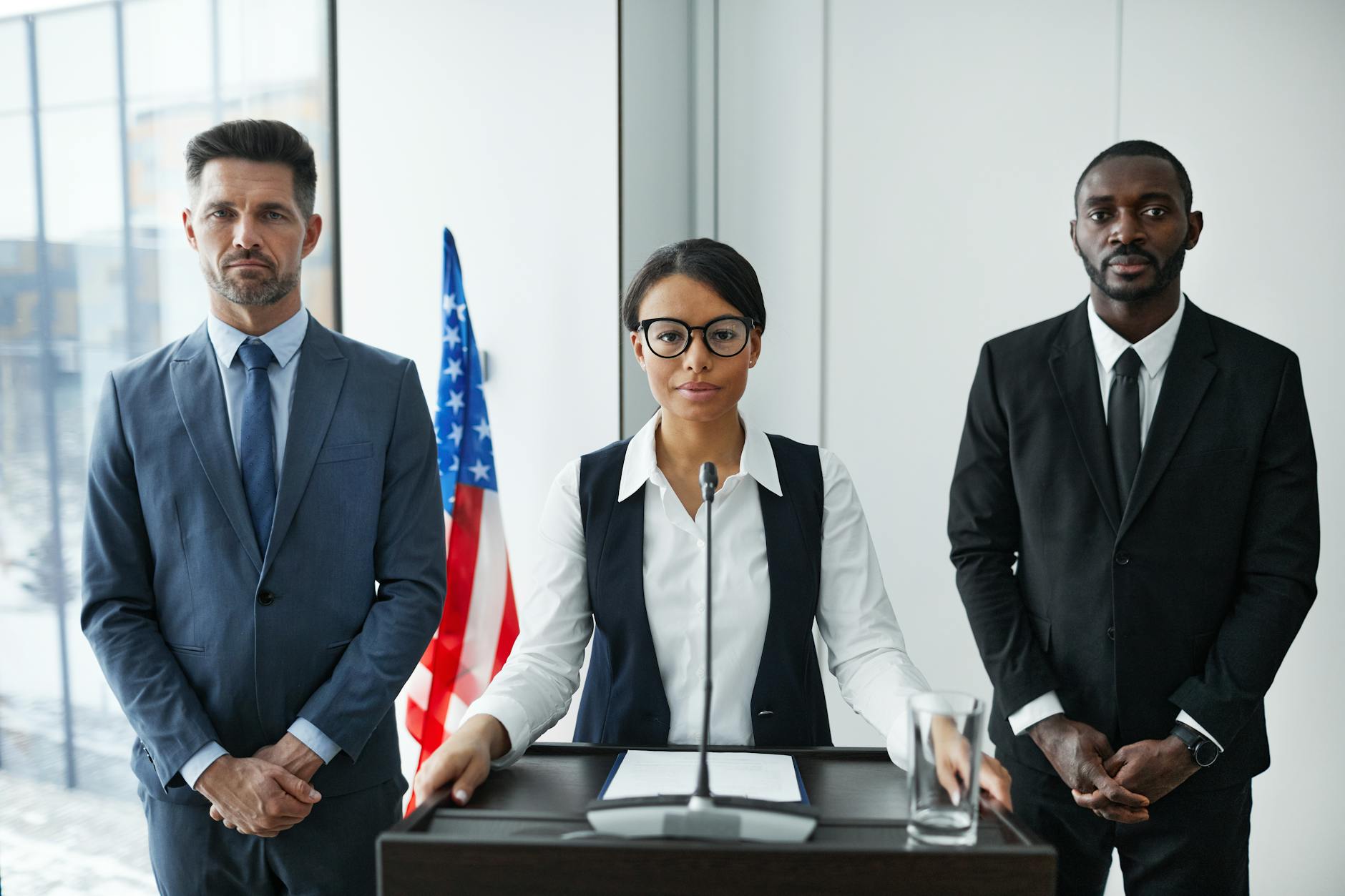 woman standing between men in suits