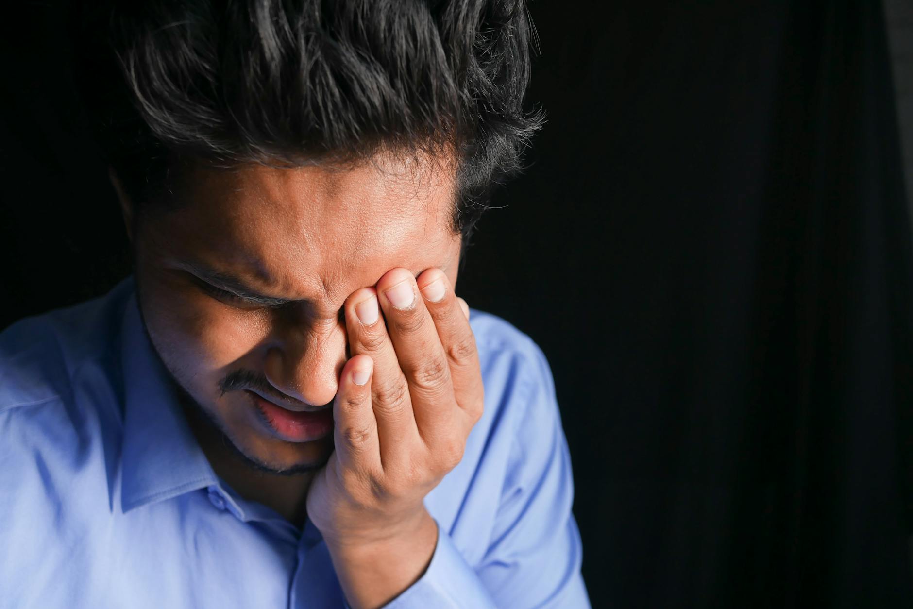 close up shot of a man touching his eye